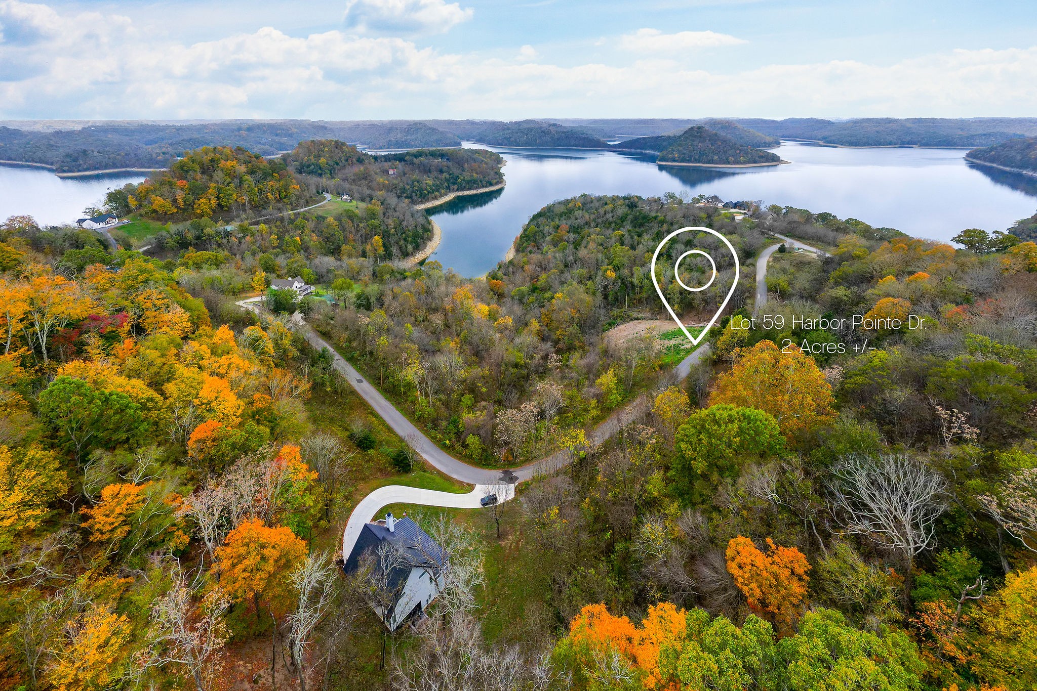 an aerial view of a house with a yard and lake view