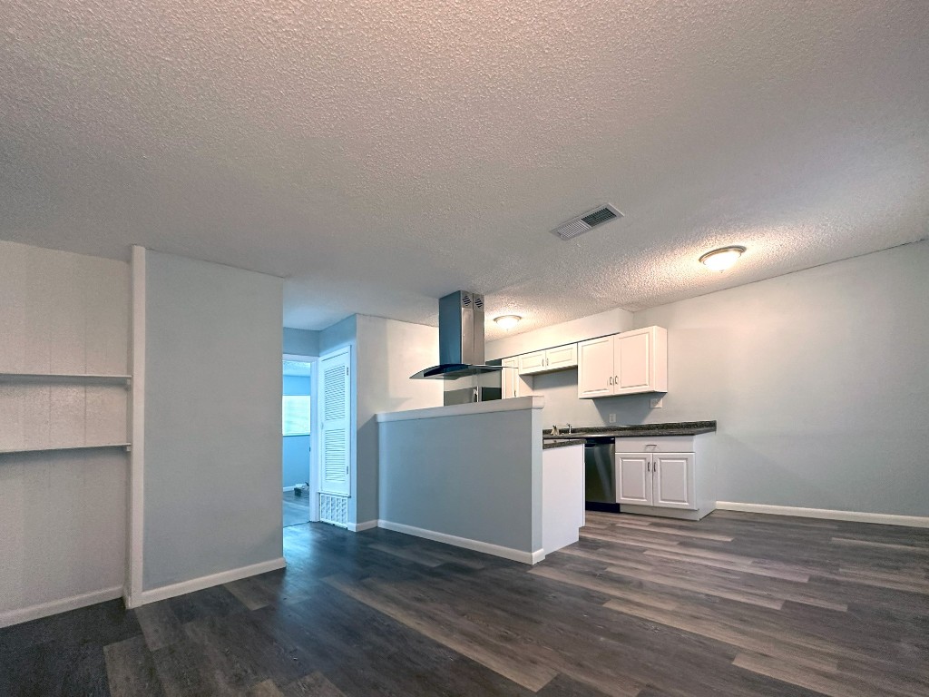 a kitchen with a sink cabinets and wooden floor