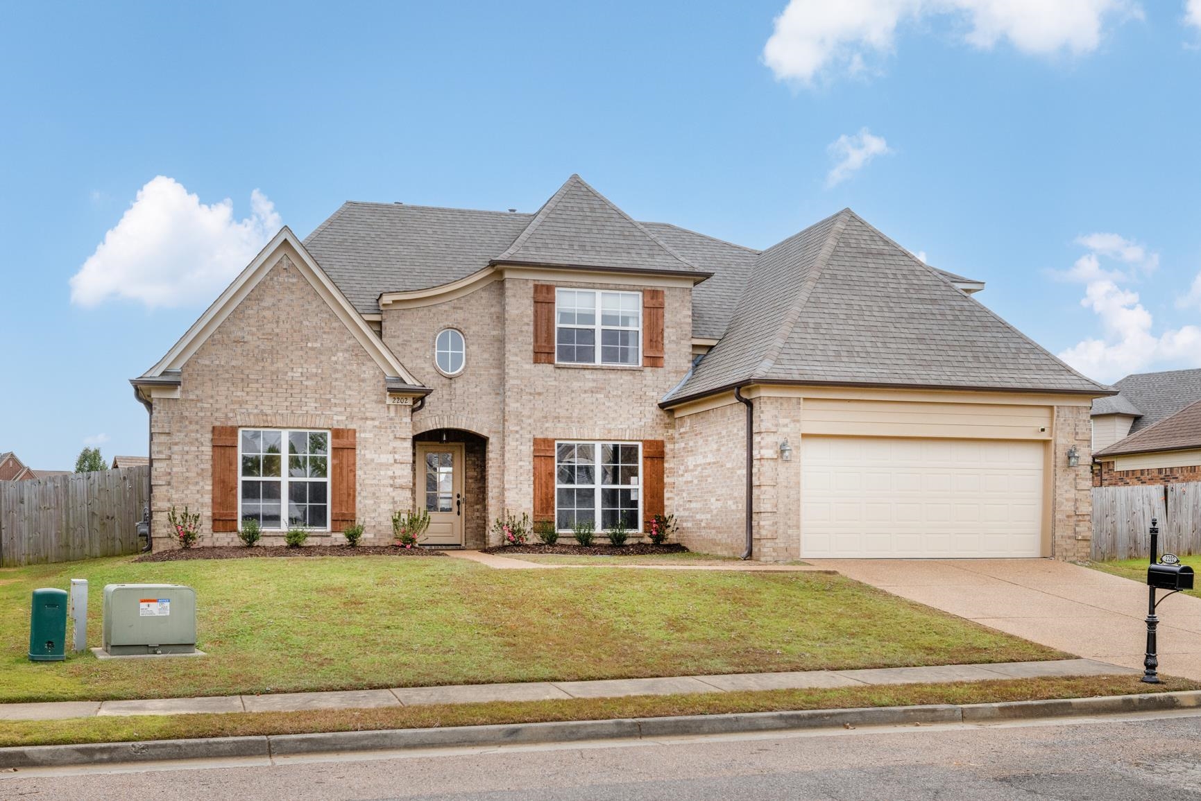 a front view of a house with a garden and garage