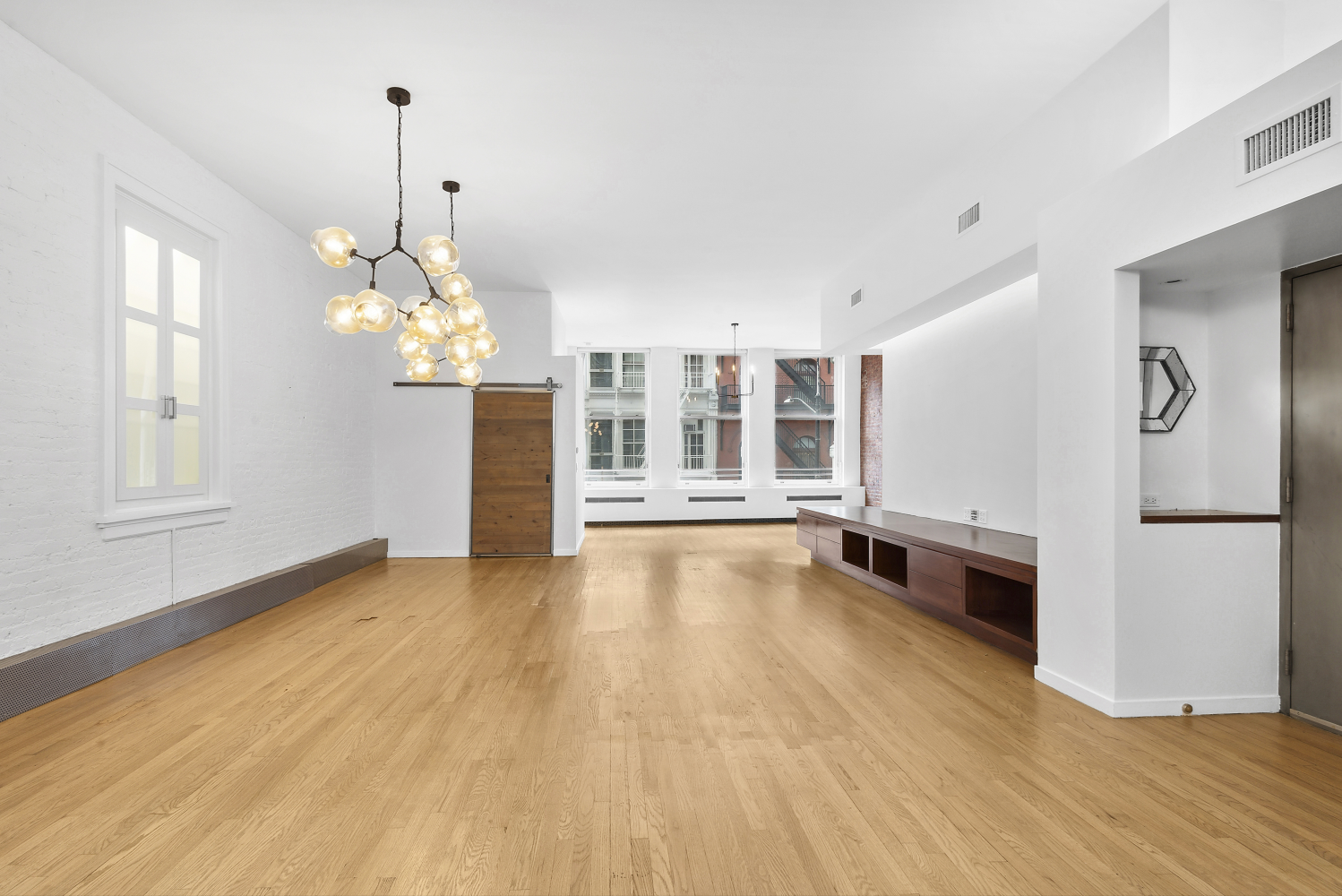 a view of a room with wooden floor and kitchen