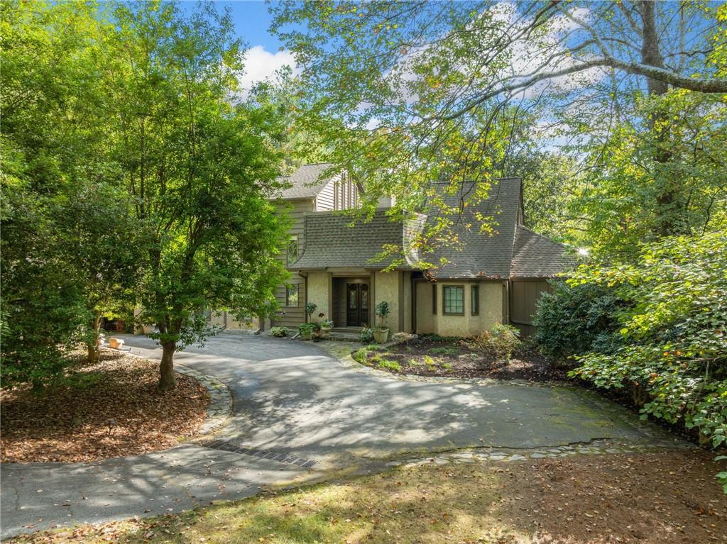 a front view of a house with a tree