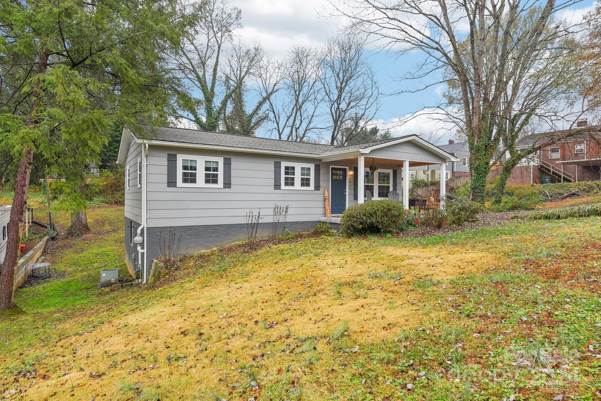 a front view of house with yard and trees around