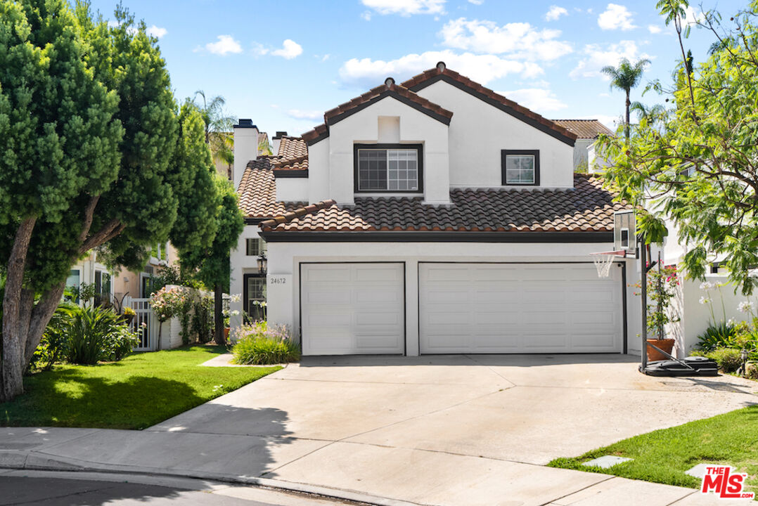 a front view of a house with a garden and garage