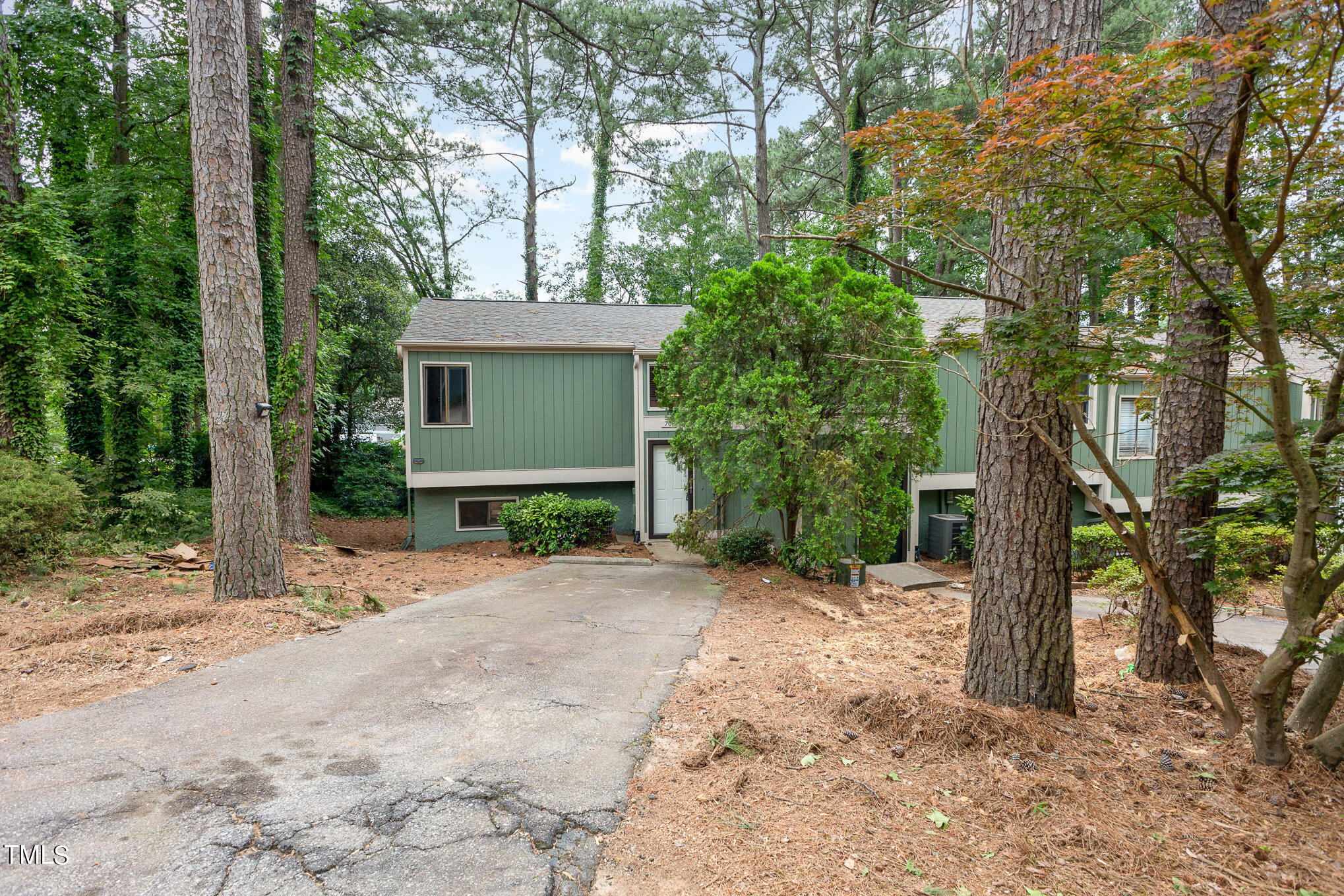 a front view of a house with a yard and tree