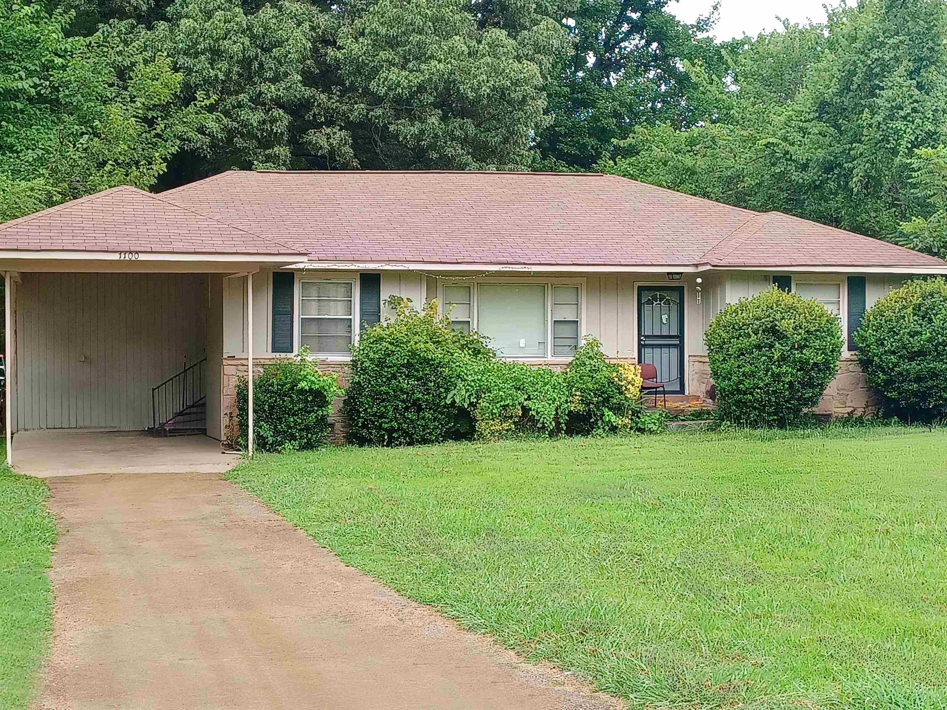 Ranch-style home featuring a carport and a front yard