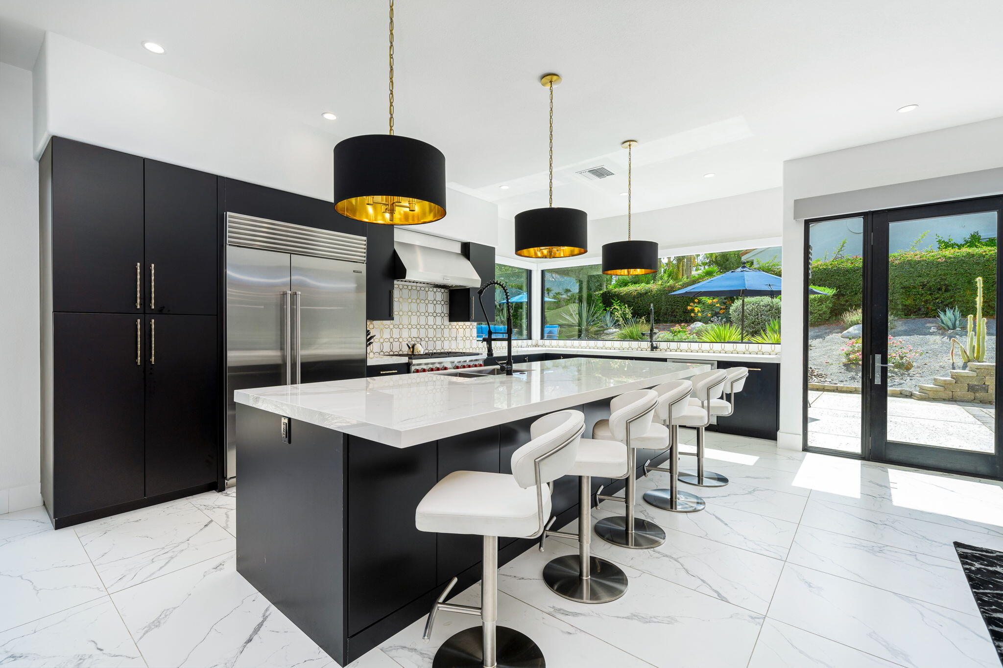 a kitchen with stainless steel appliances kitchen island granite countertop a table and chairs