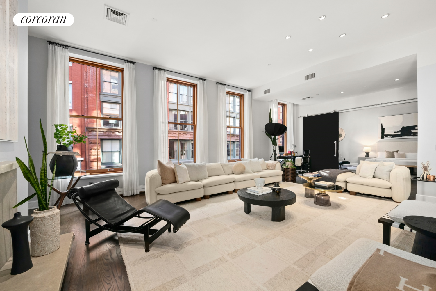 a living room with fireplace furniture and floor to ceiling windows