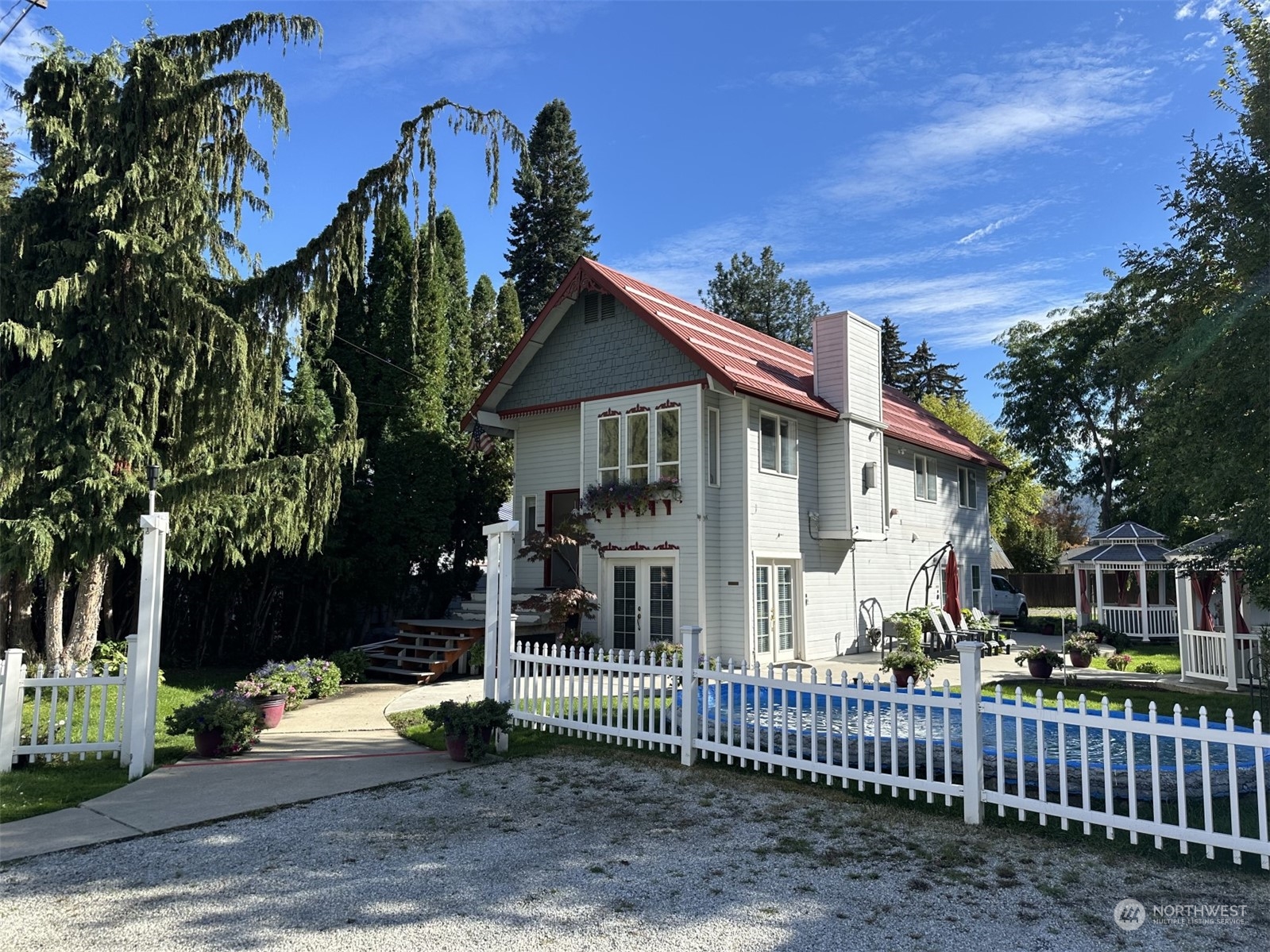 a view of a house with a small yard and wooden fence