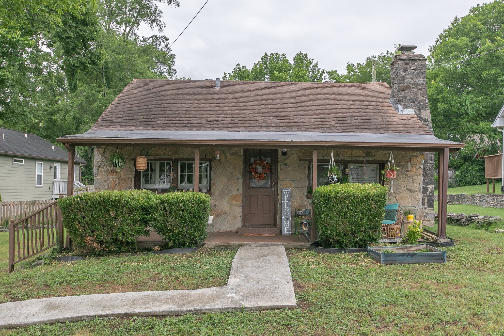 a front view of a house with a yard and potted plants