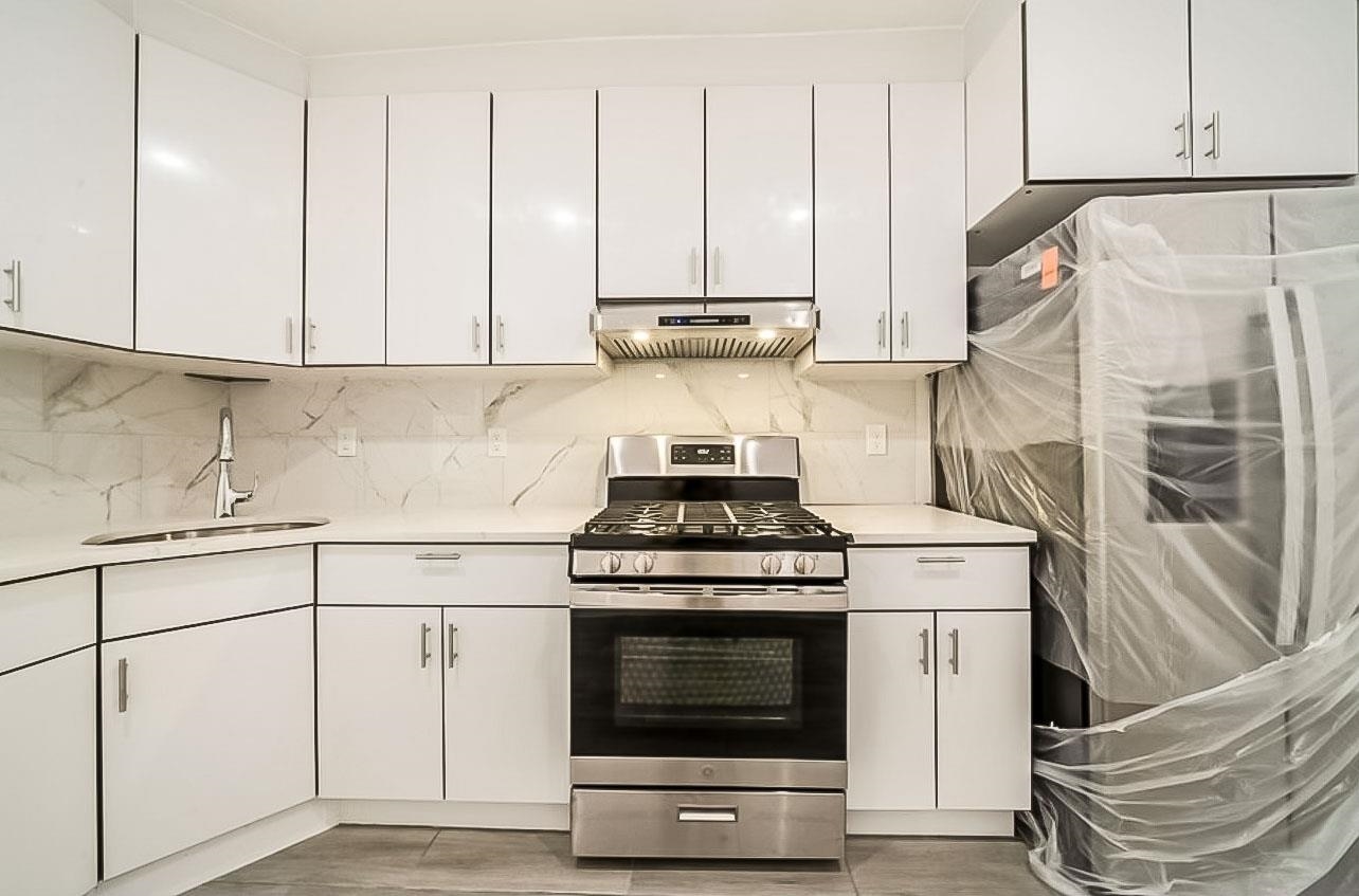 a kitchen with granite countertop white cabinets and white appliances