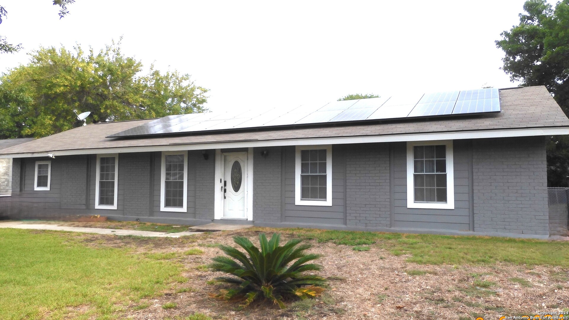 a front view of a house with a garden