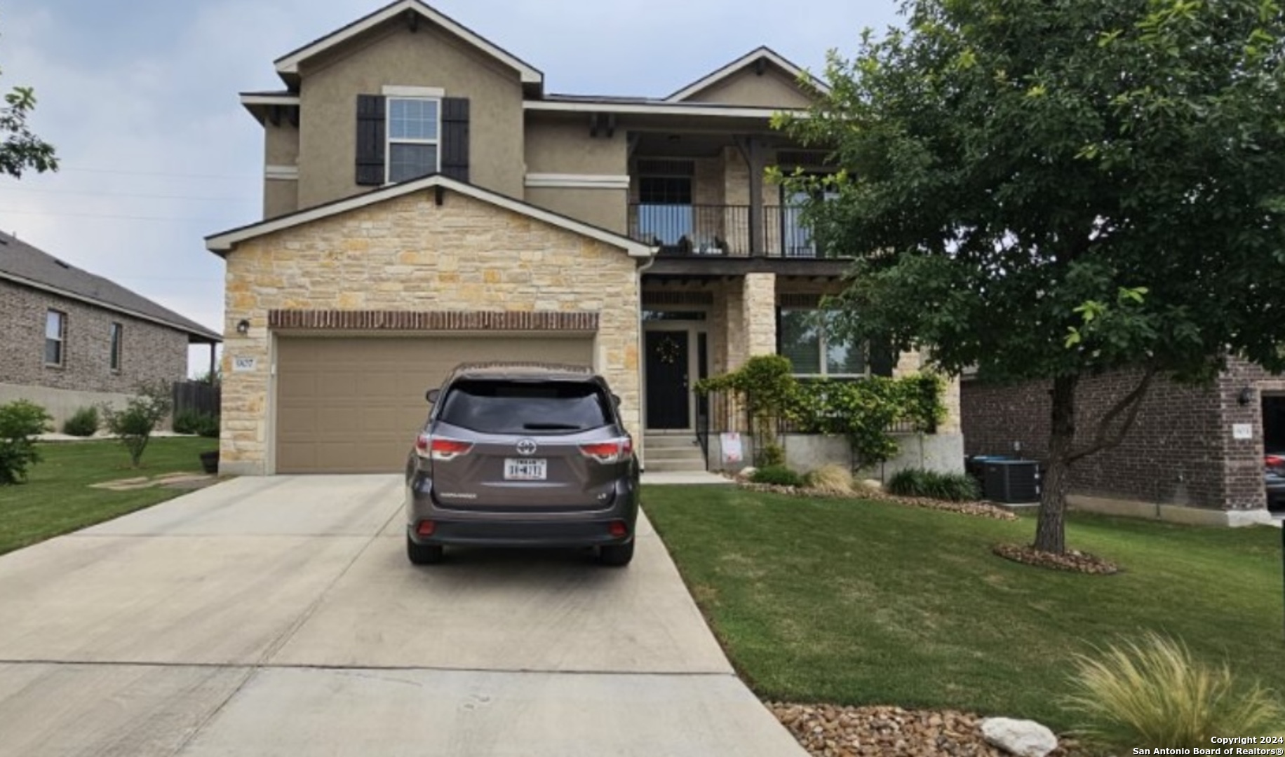 a view of a house with a cars park side of the road