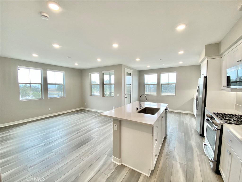 a kitchen with stainless steel appliances granite countertop a stove and a wooden floors