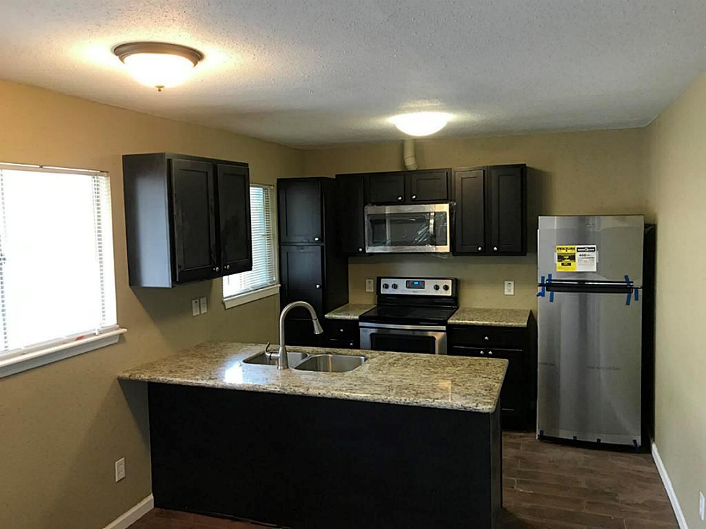 a kitchen with kitchen island a sink stainless steel appliances and window