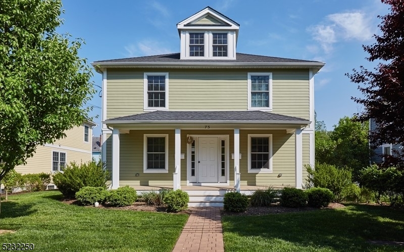 a front view of a house with a yard and trees