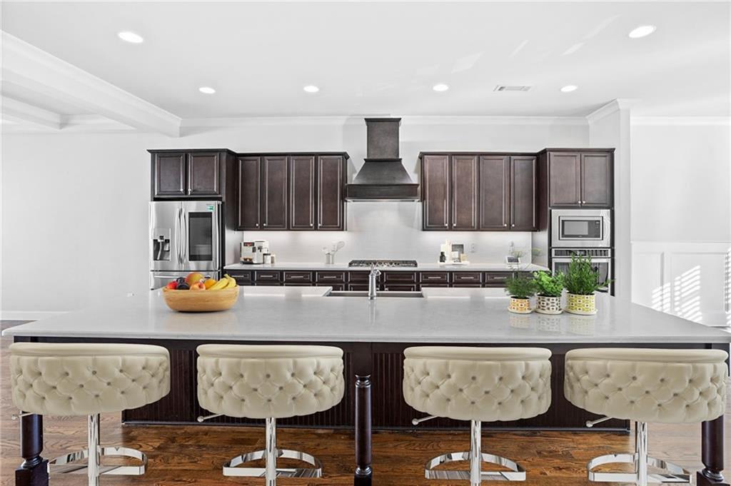 a kitchen with granite countertop lots of wooden cabinets and chairs