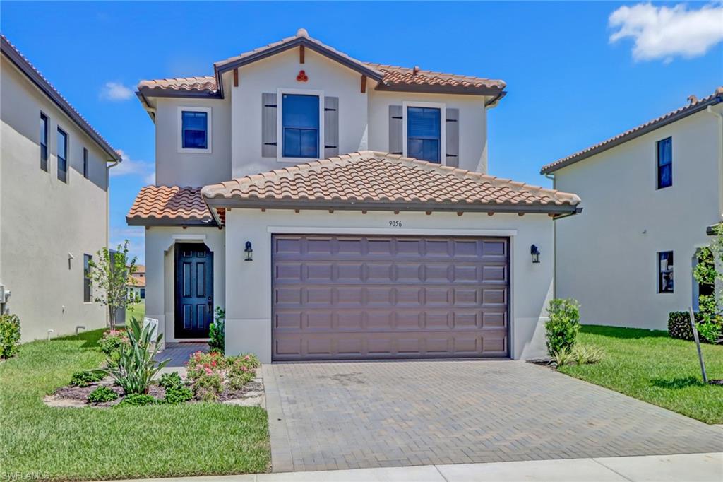 Mediterranean / spanish house with a garage and a front yard