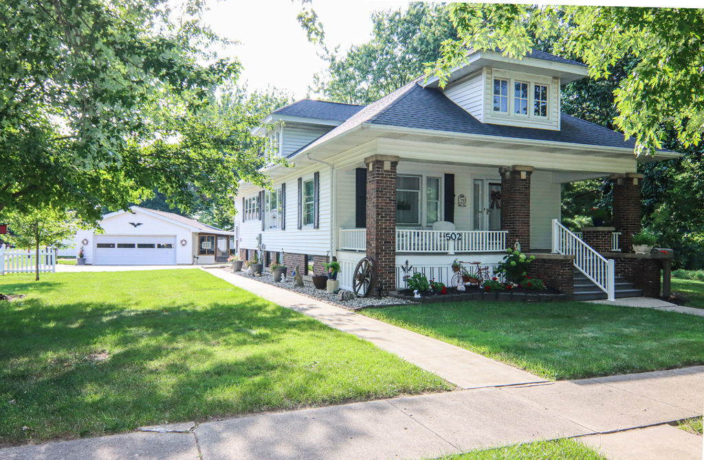 a front view of a house with a garden and yard