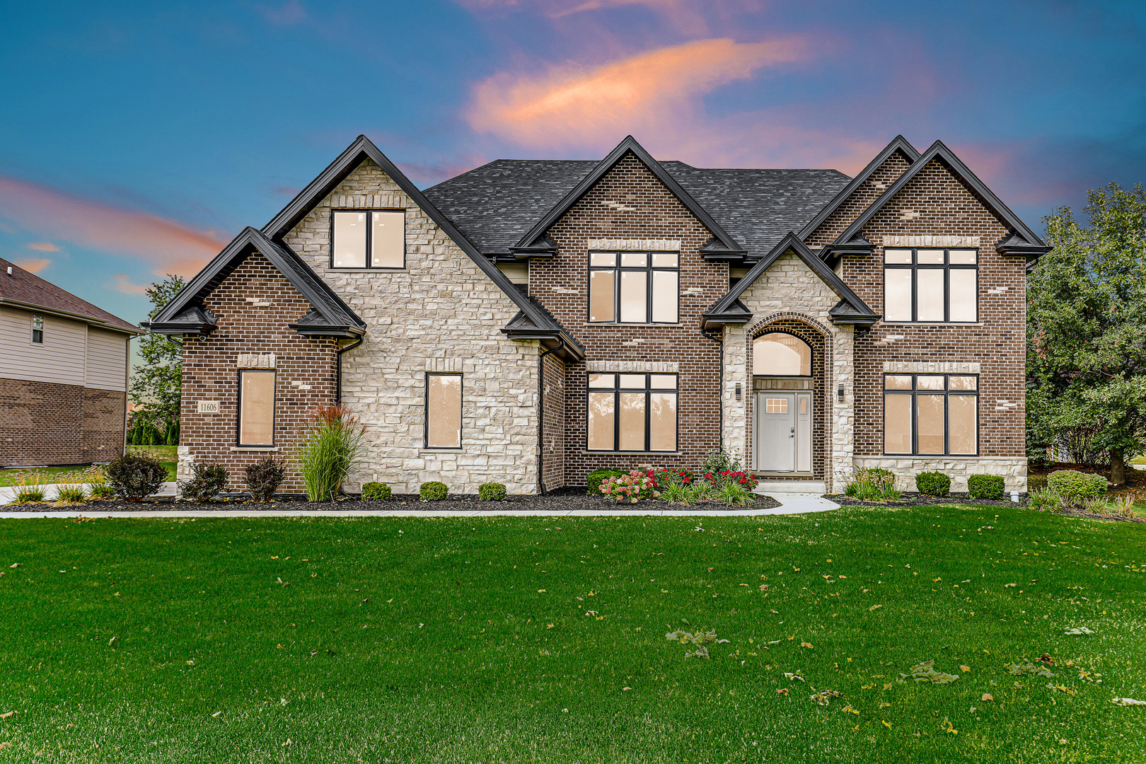 a front view of a house with a yard and green space