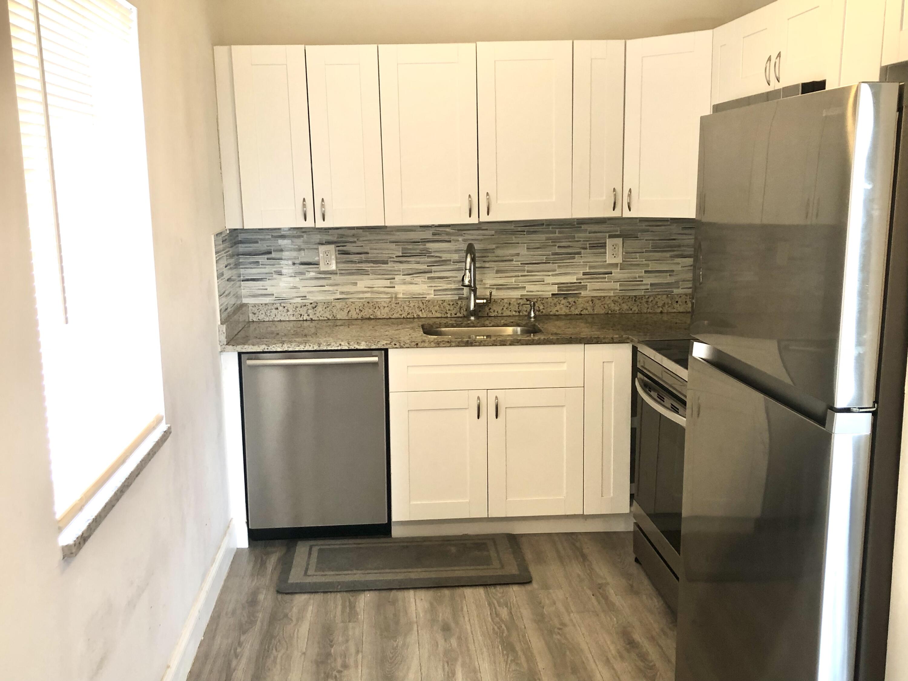 a kitchen with stainless steel appliances granite countertop a refrigerator and a stove