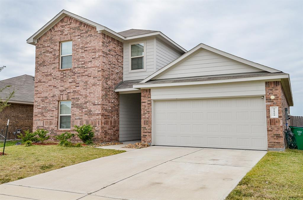 front view of house with a yard and garage