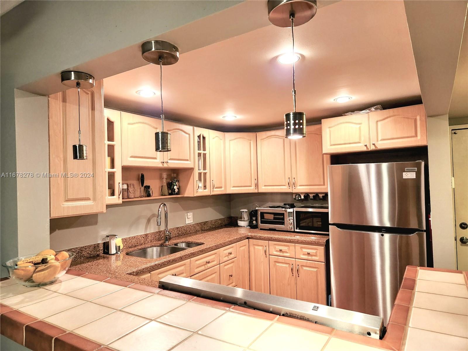 a kitchen with stainless steel appliances granite countertop a sink refrigerator and microwave