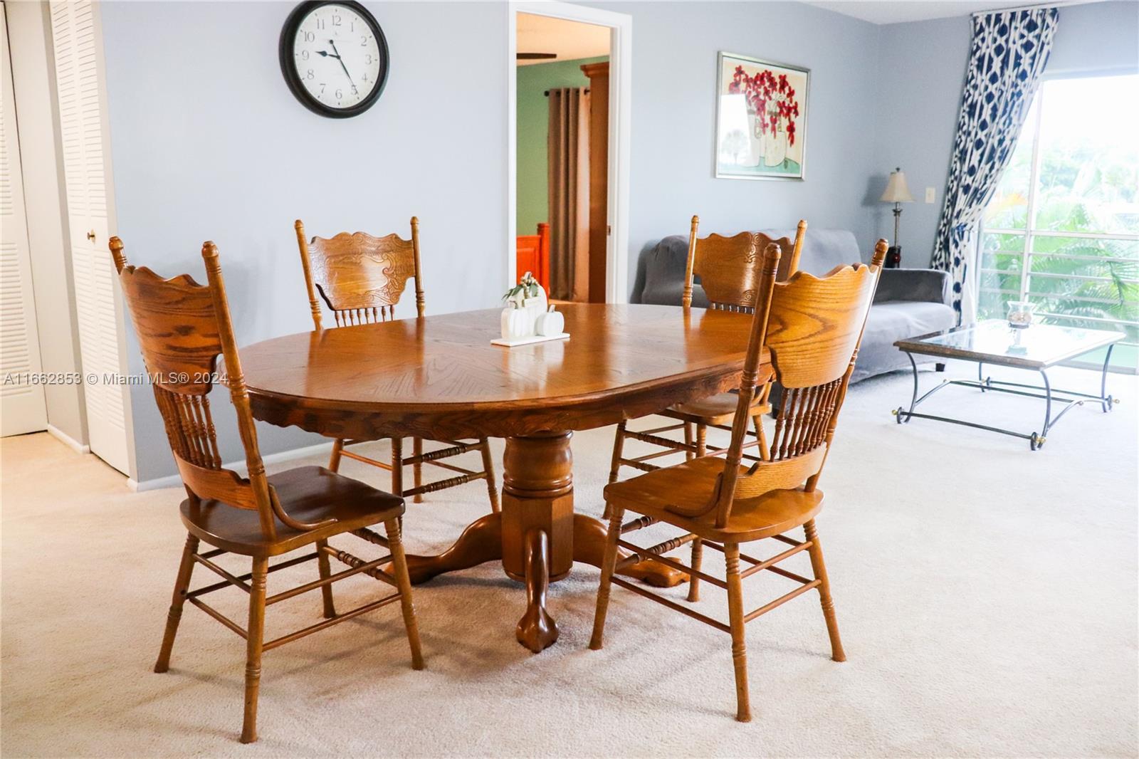 a dining room with furniture and a large window