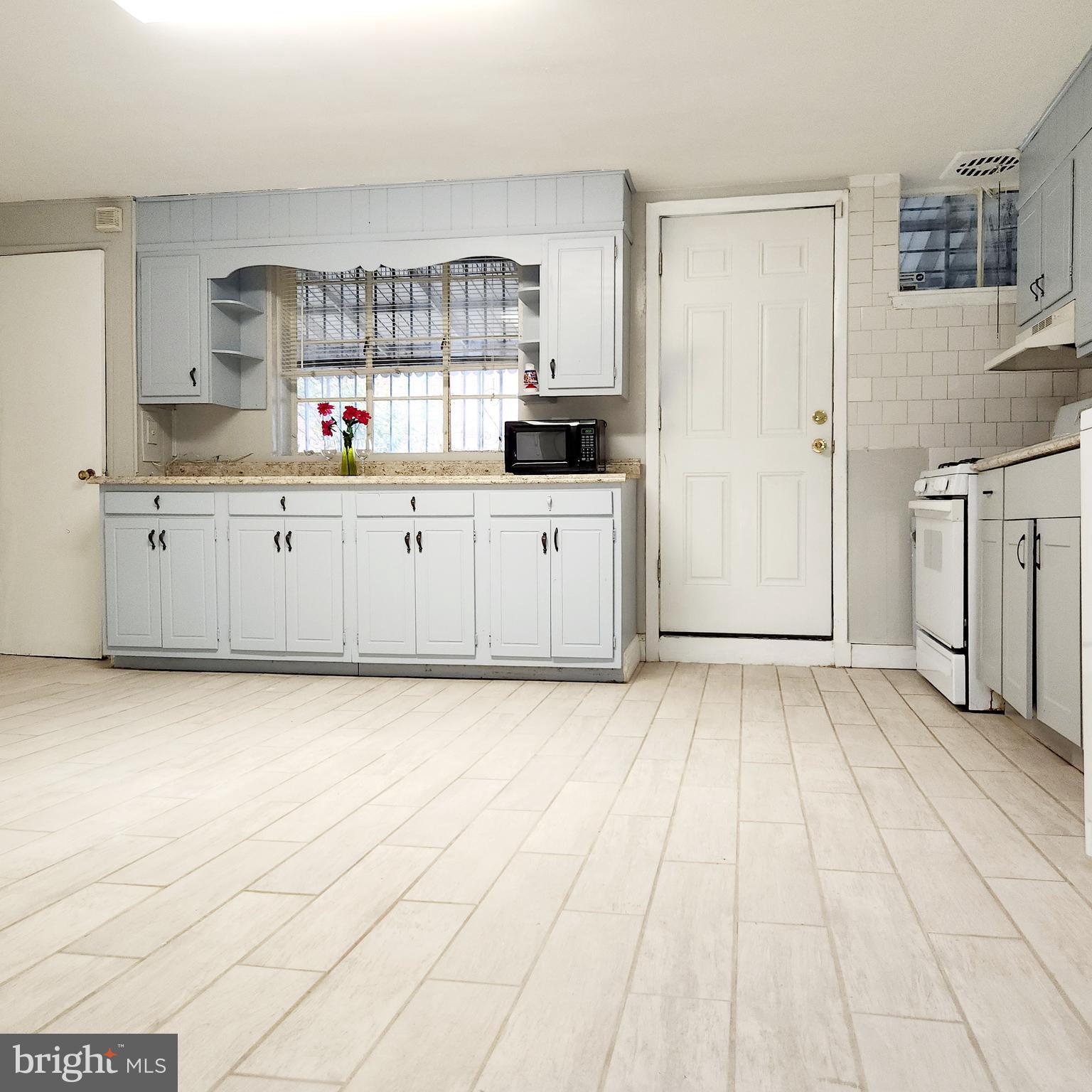 a kitchen with granite countertop a stove a sink and a refrigerator