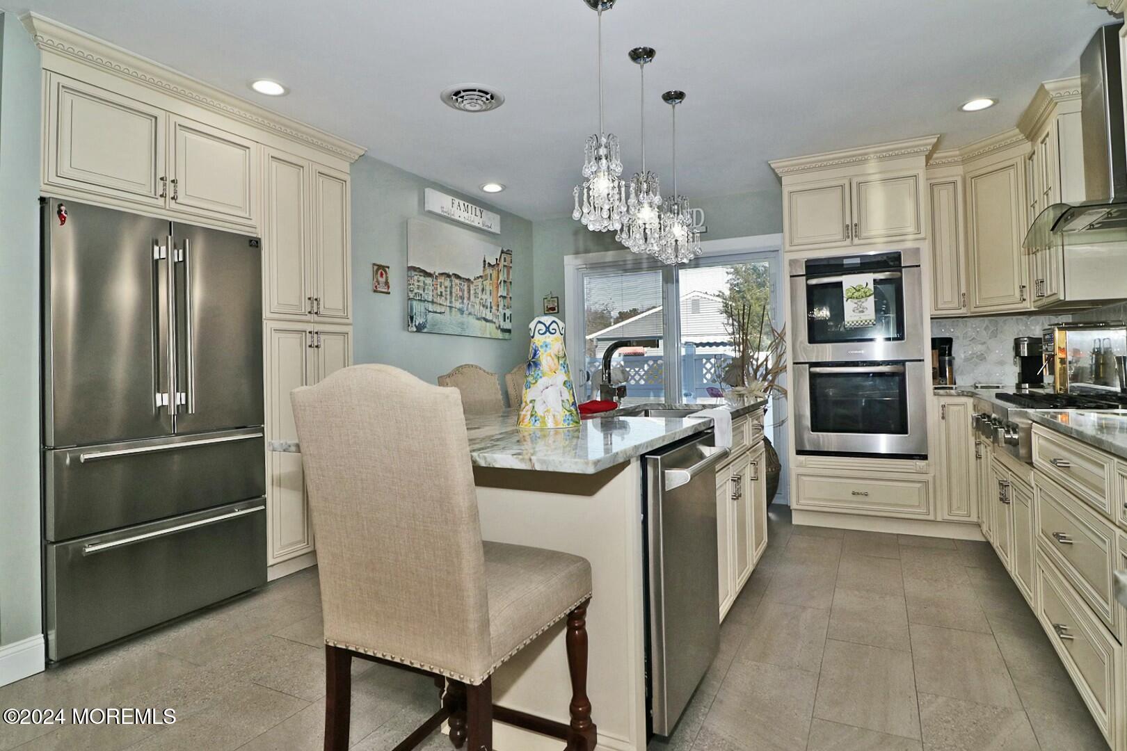 a kitchen with stainless steel appliances granite countertop a refrigerator and a stove top oven