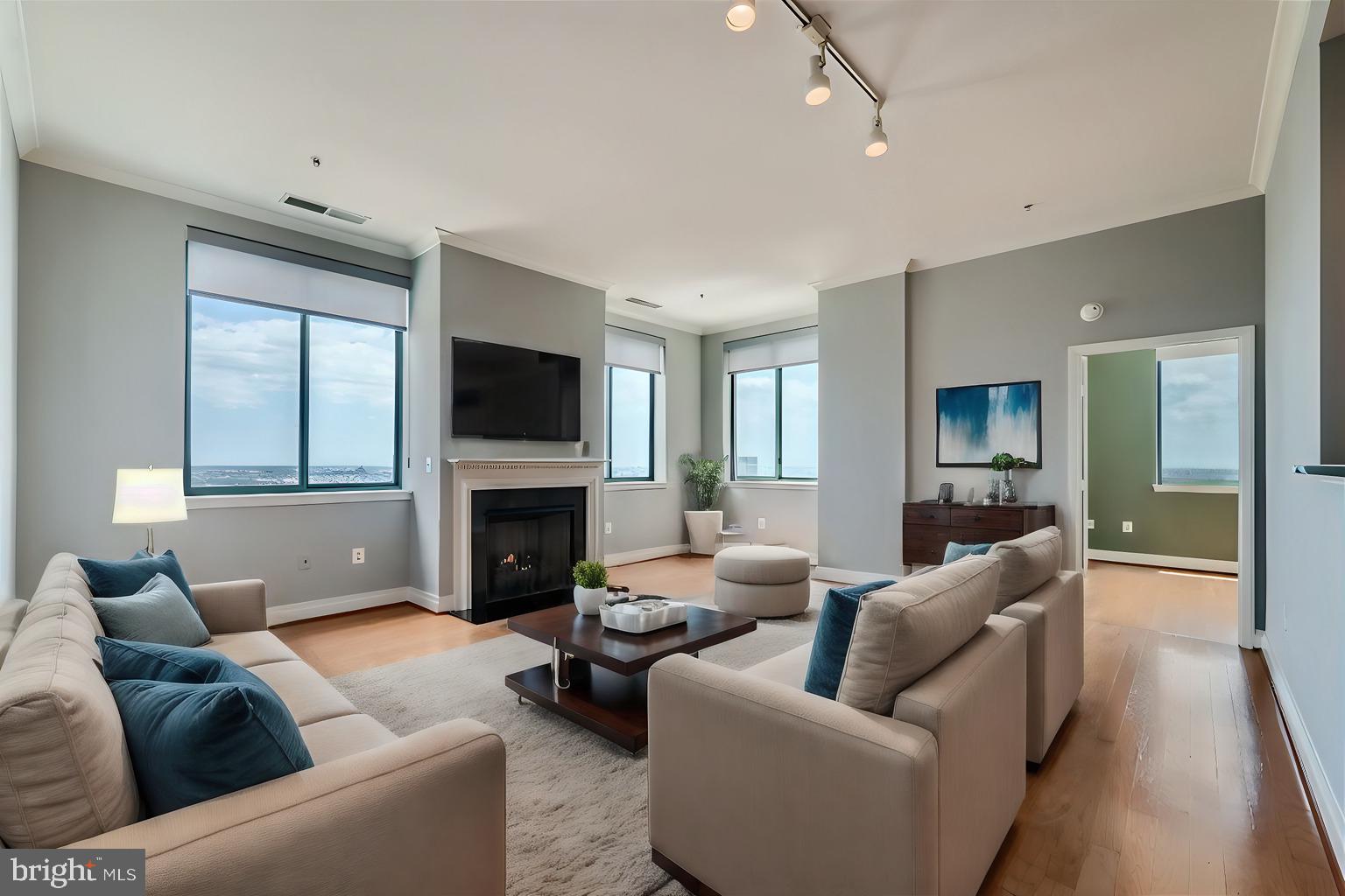 a living room with furniture a fireplace a flat screen tv and a window