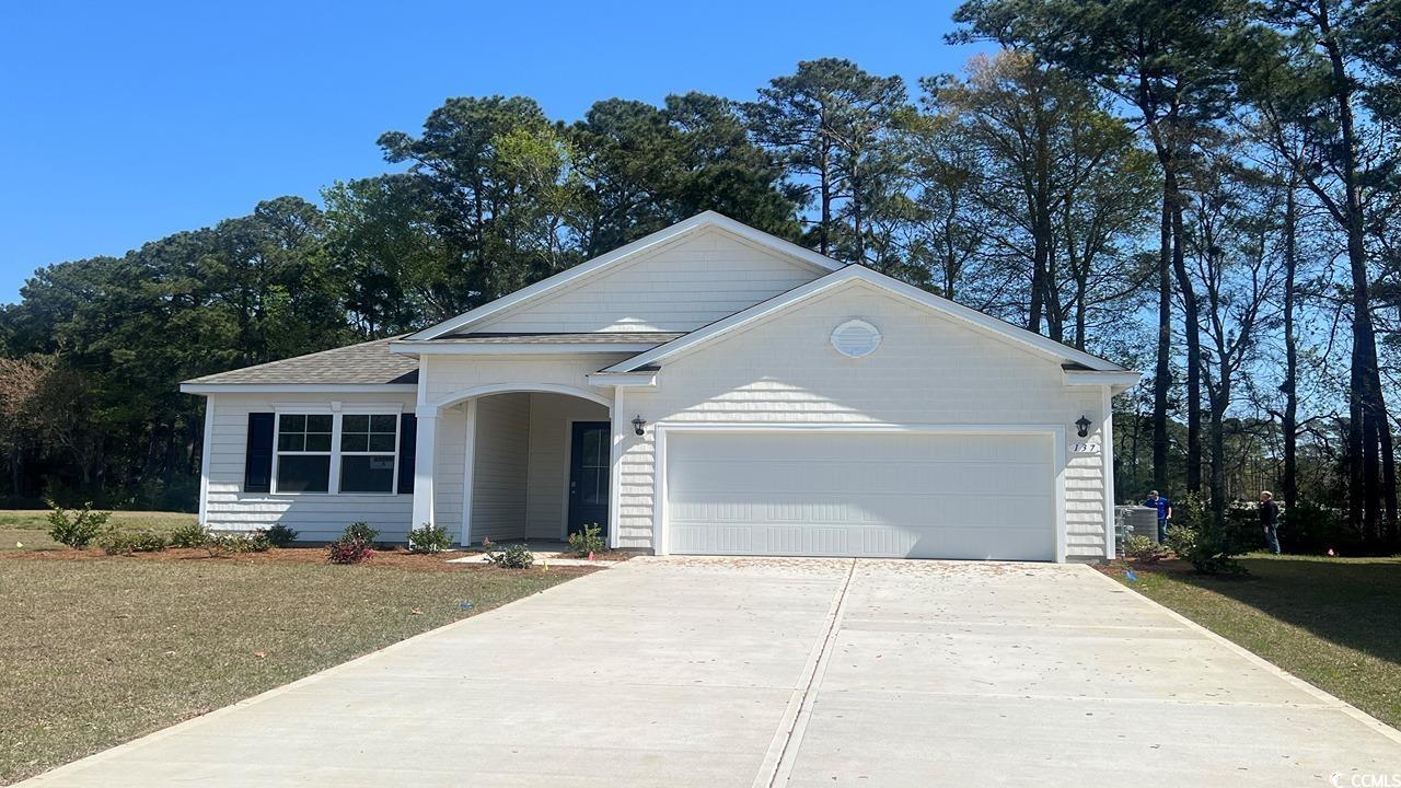 Single story home with a garage and a front lawn