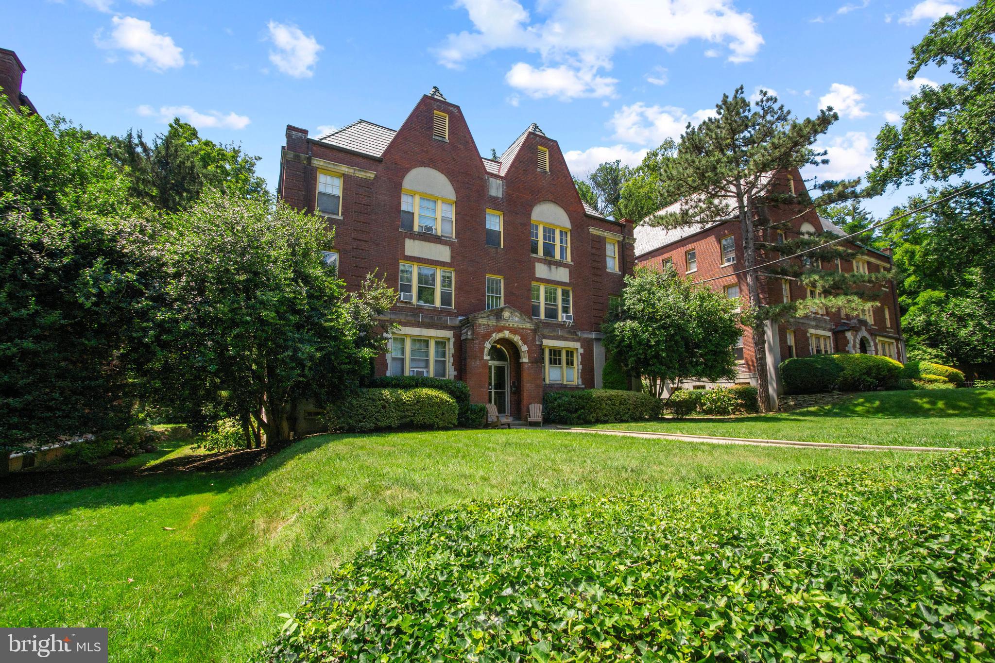 a view of a big house with a big yard and large trees