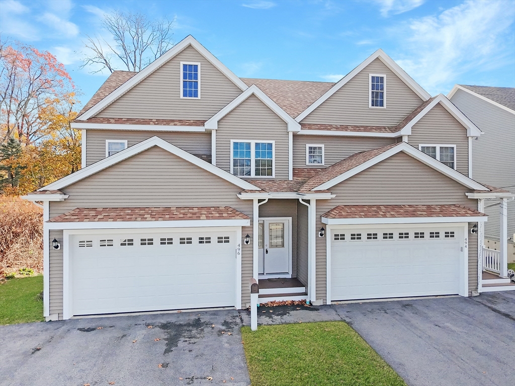 a view of a house with a yard and garage