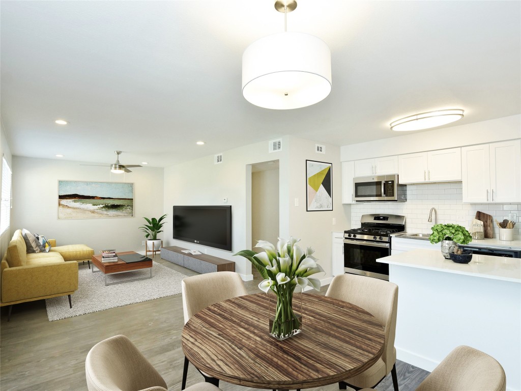 a kitchen with stainless steel appliances dining table a couch and a living room