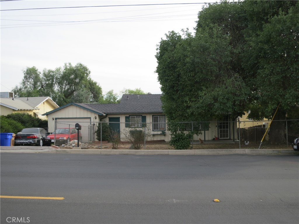 a front view of a house with a garden and trees