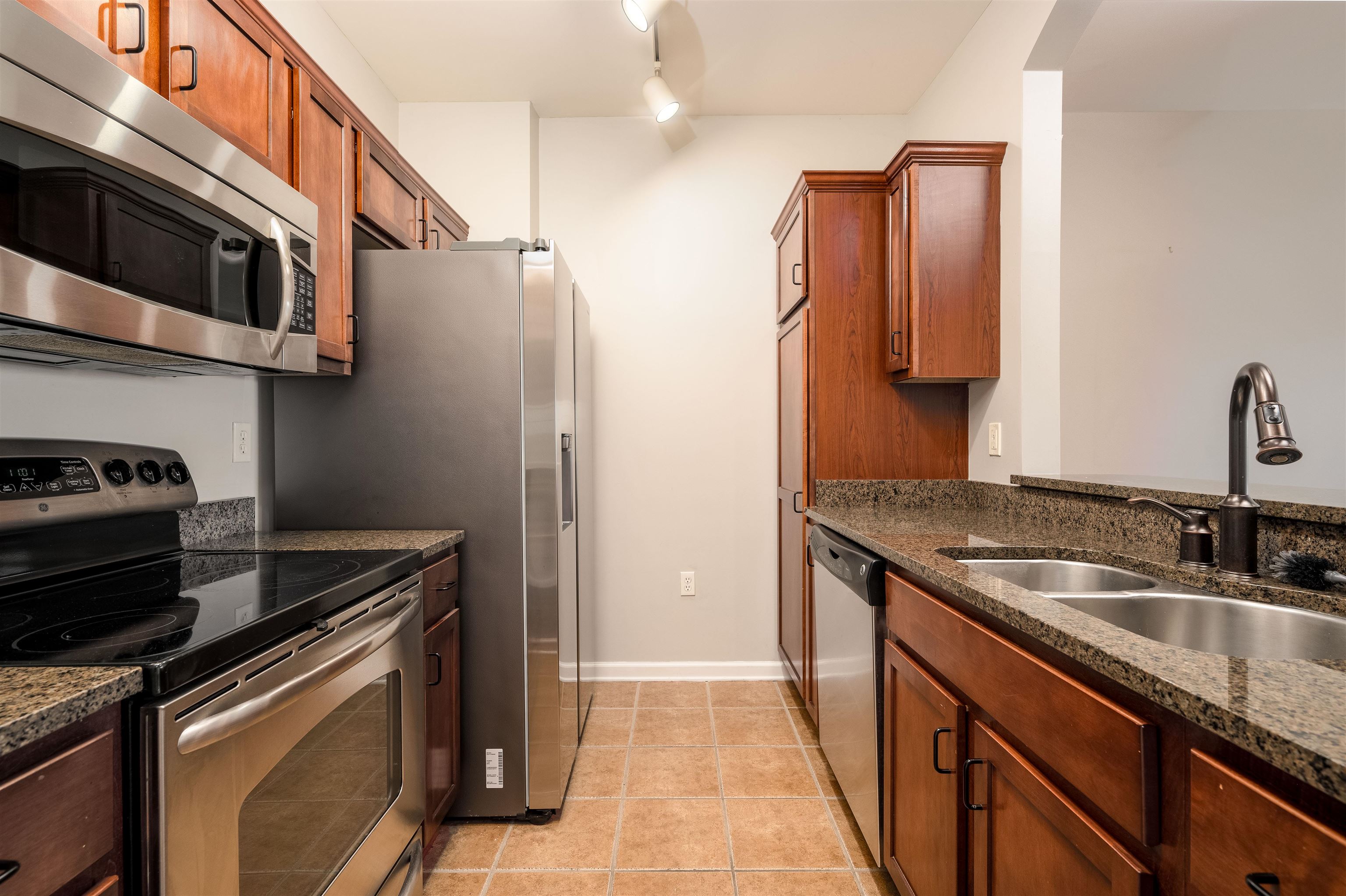 a kitchen with stainless steel appliances granite countertop a sink stove and refrigerator