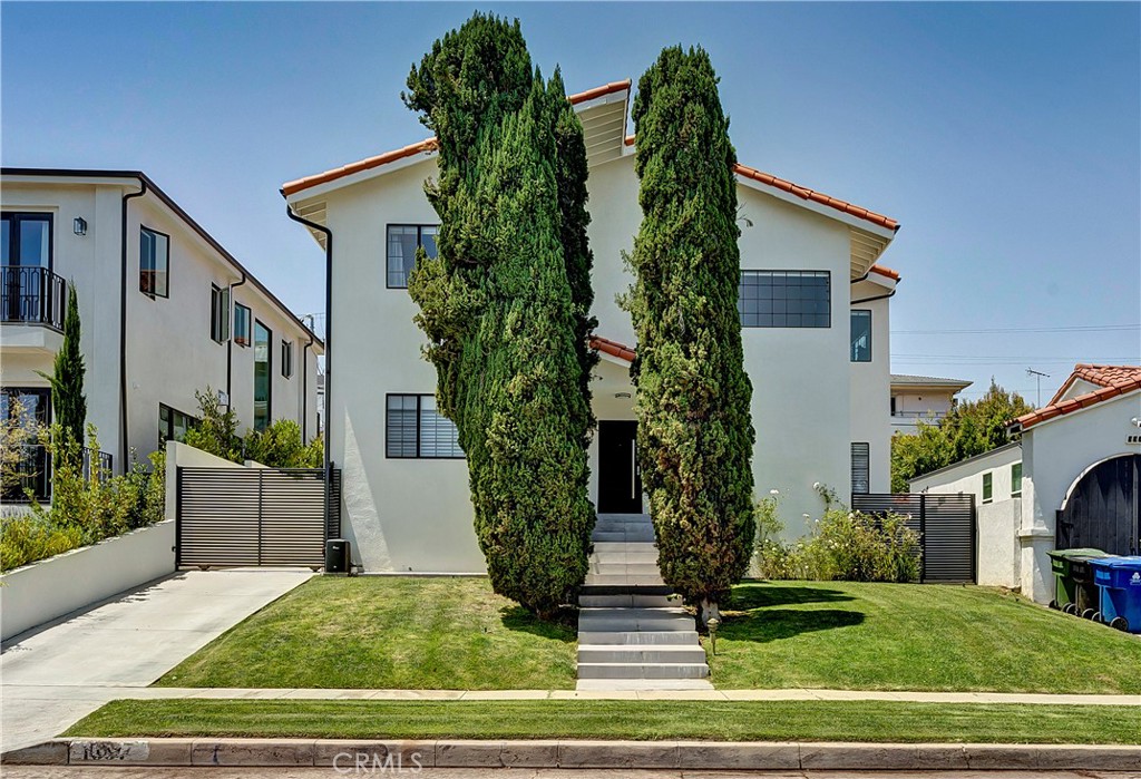 a view of a house with a yard and potted plants