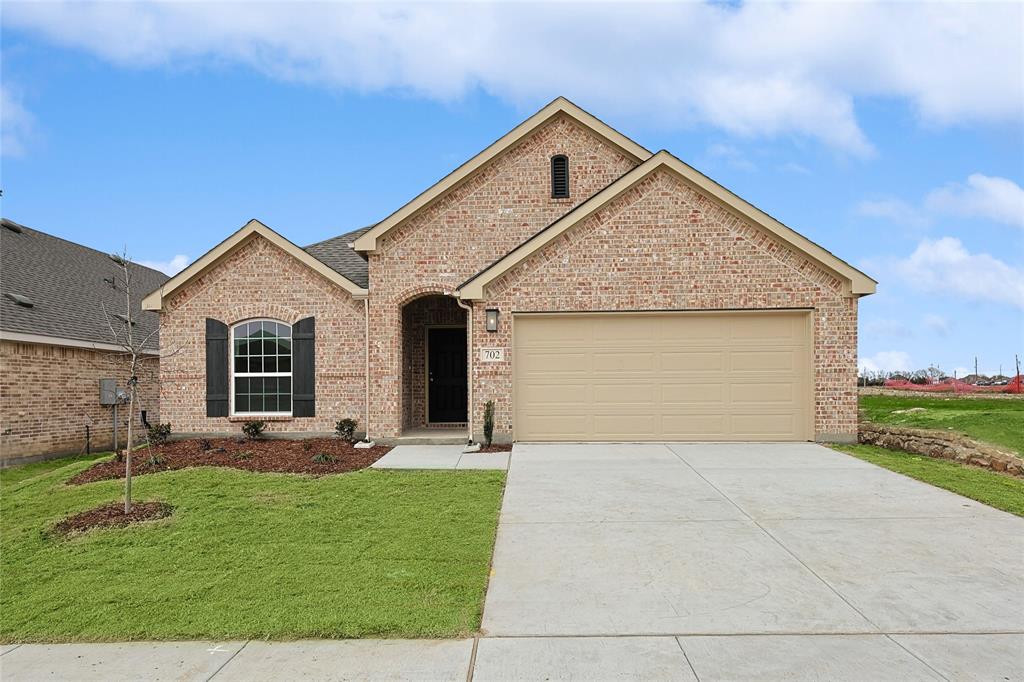 View of front of home with a garage and a front lawn