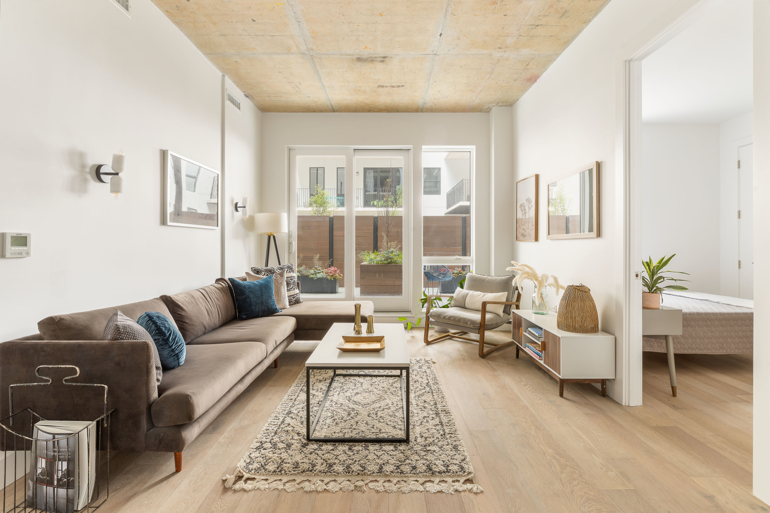 a living room with furniture wooden floor and a large window