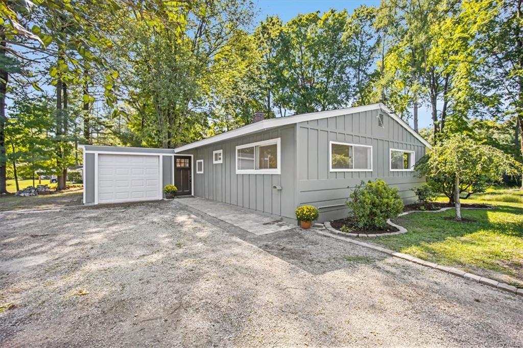 View of front of property with a garage and a front lawn