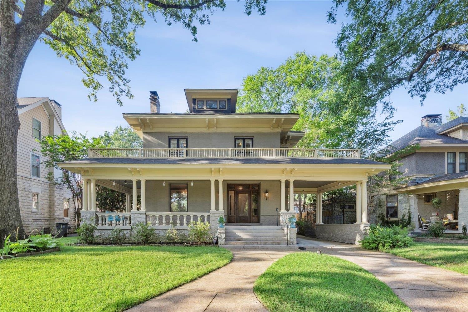 View of front of home featuring covered porch, a balcony, and a front lawn