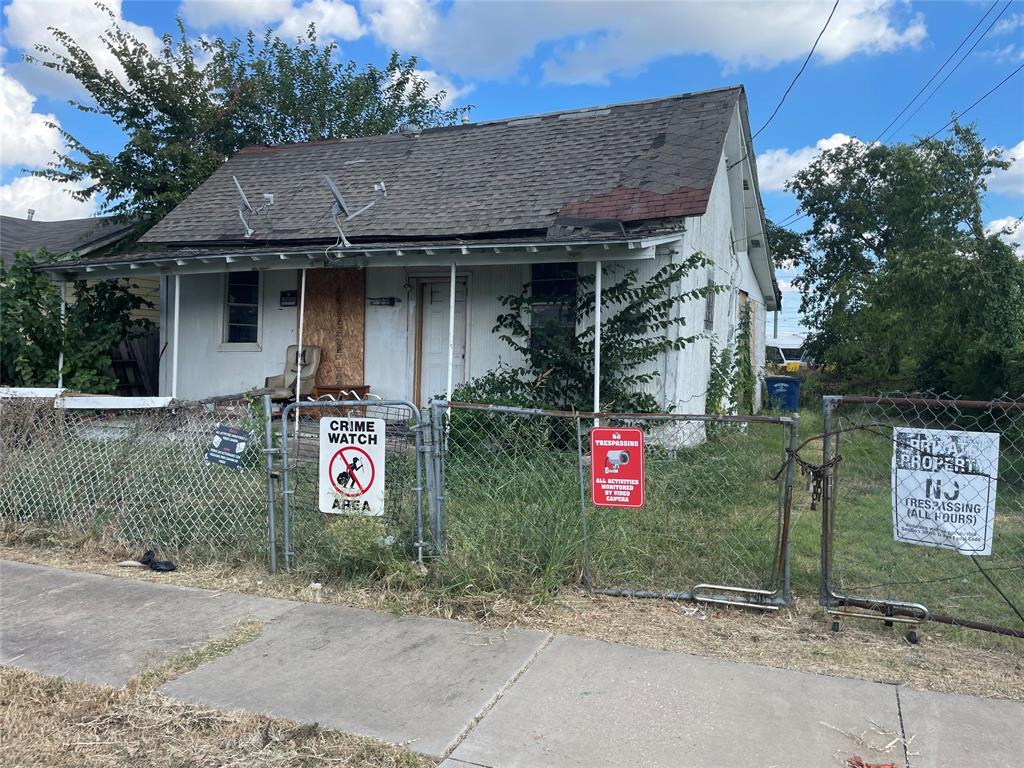 a front view of a house with sign board and yard