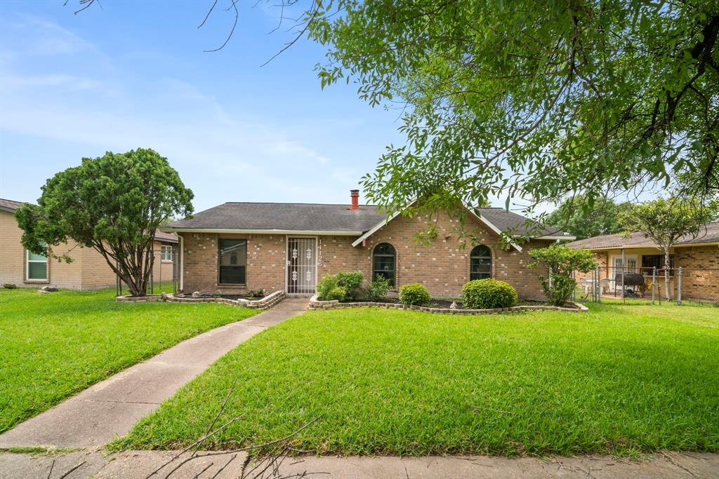 a front view of a house with a yard and trees