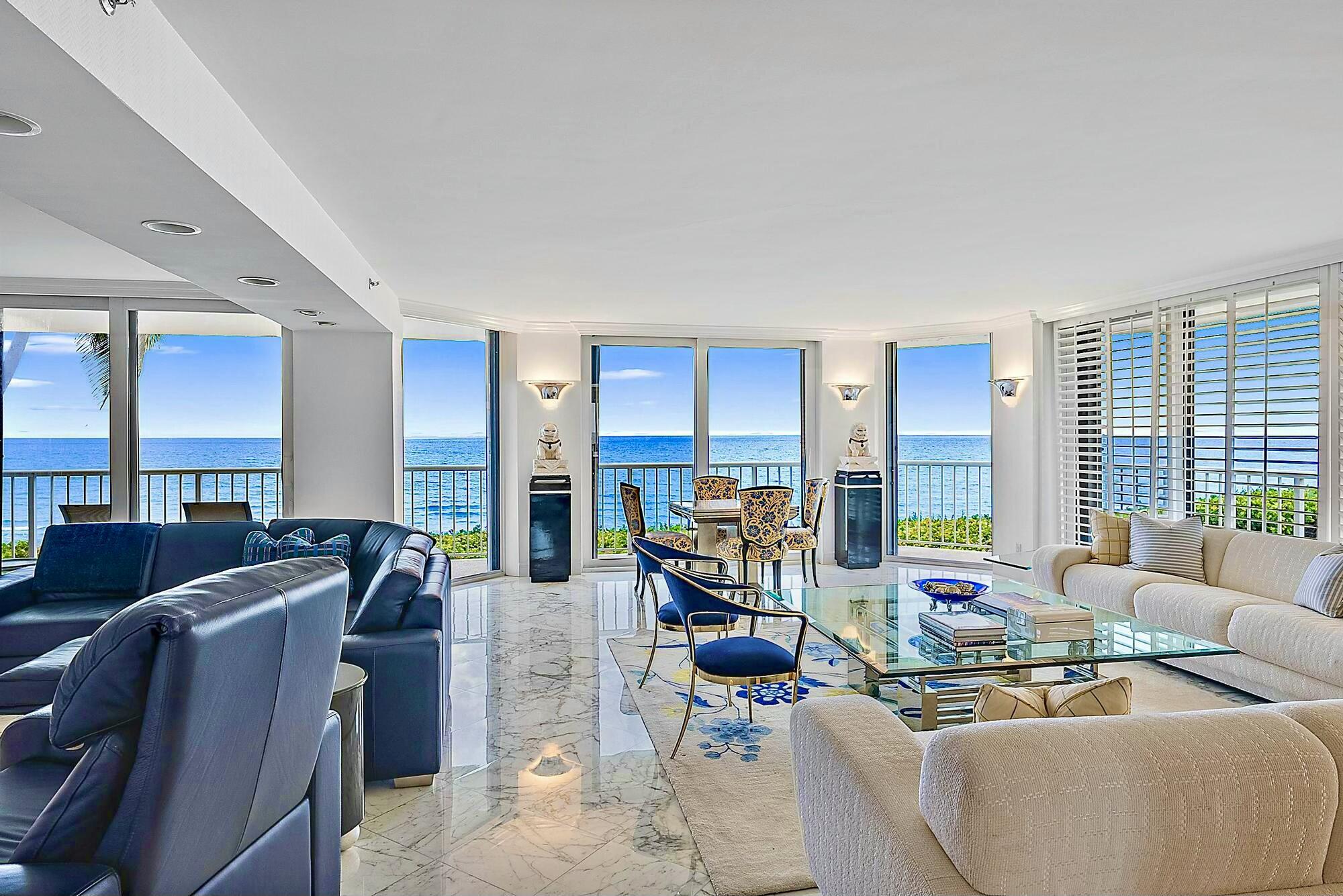 a living room with furniture kitchen view and large windows