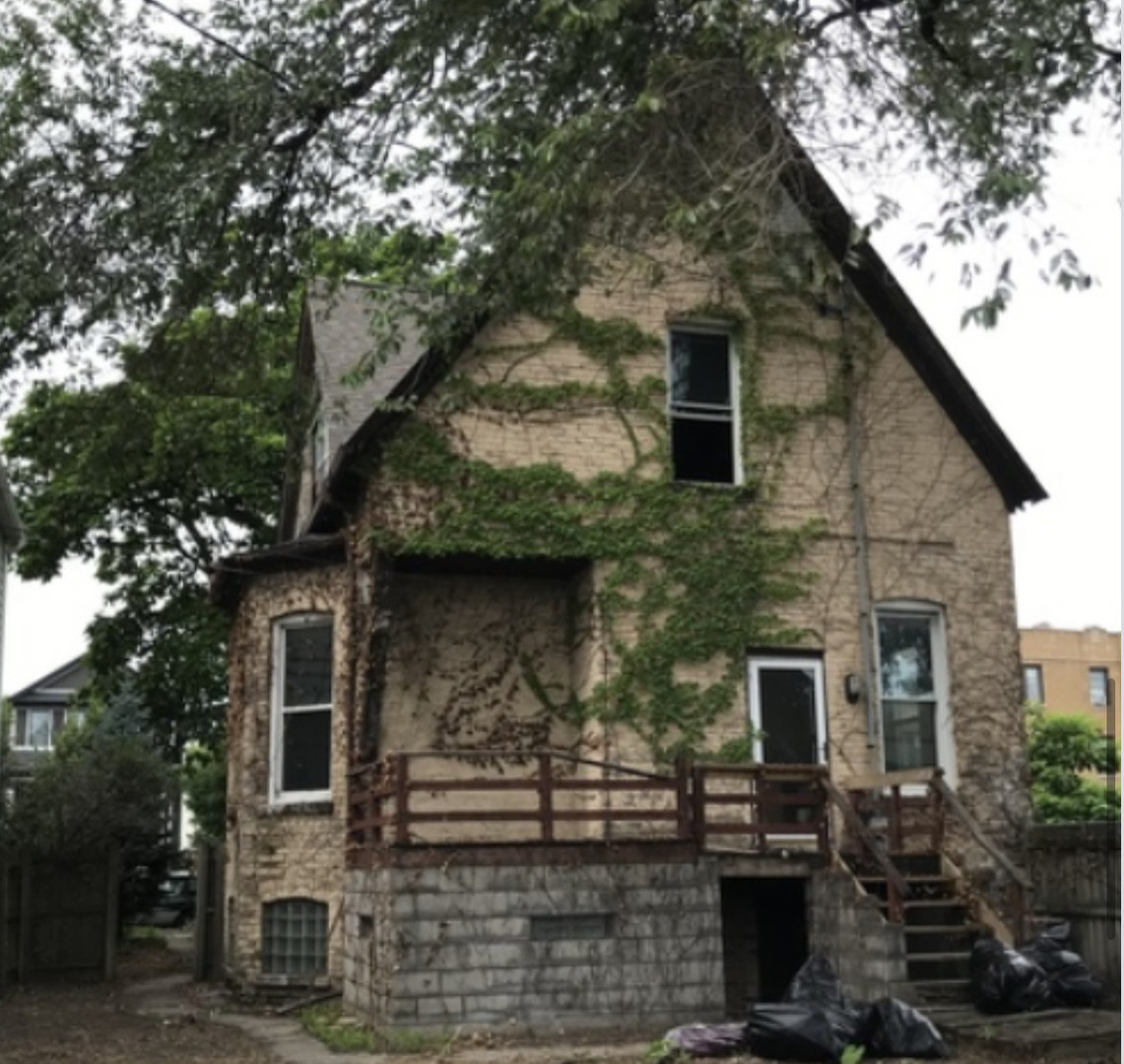 a front view of a house with plants