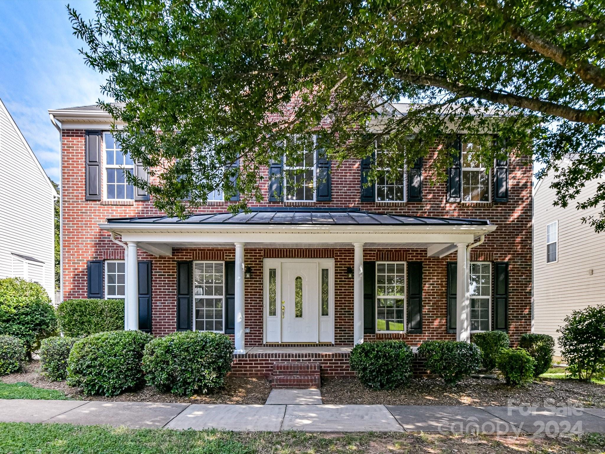 front view of a brick house with a small yard