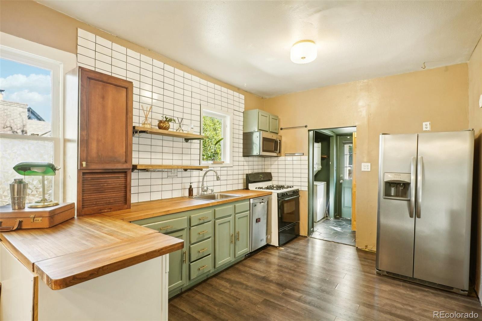 a kitchen with stainless steel appliances granite countertop a sink a stove and a refrigerator