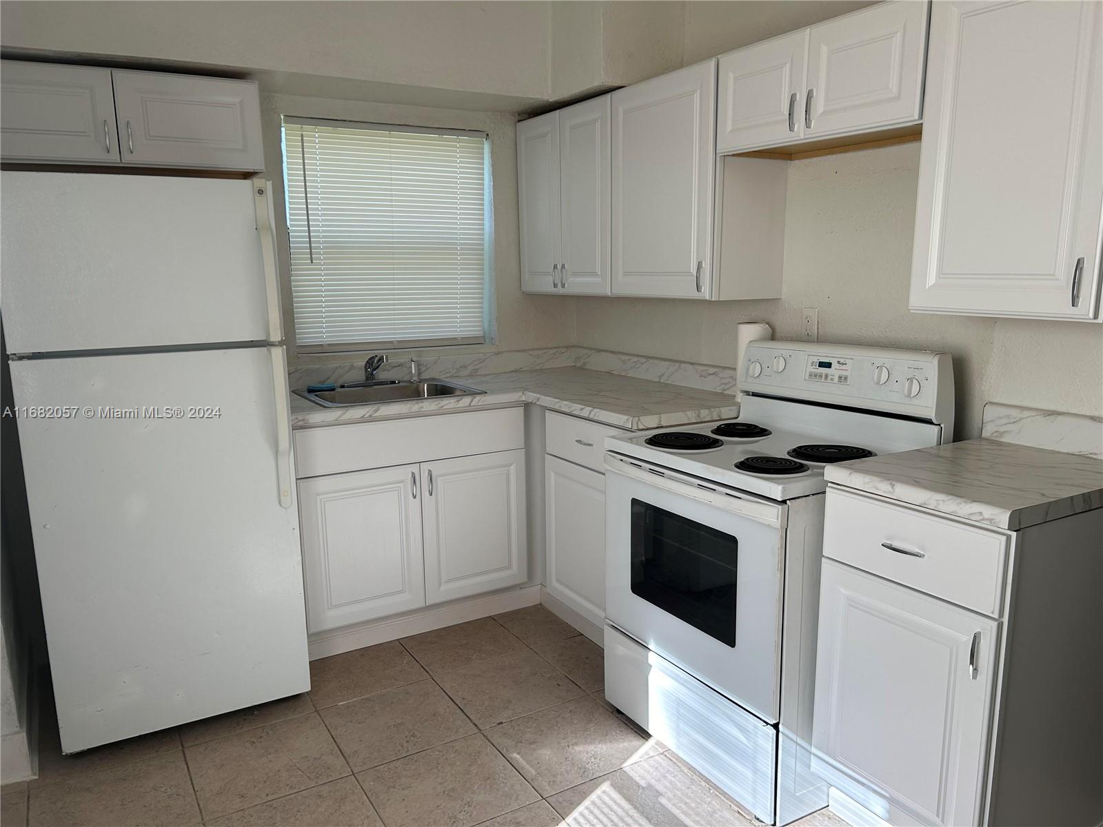 a kitchen with white cabinets and white appliances