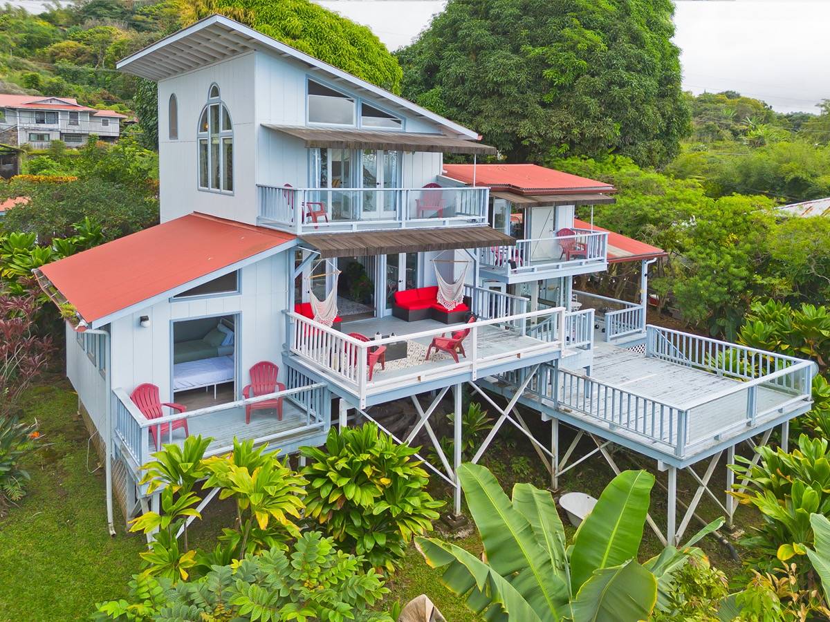 an aerial view of a house with table and chairs under an umbrella