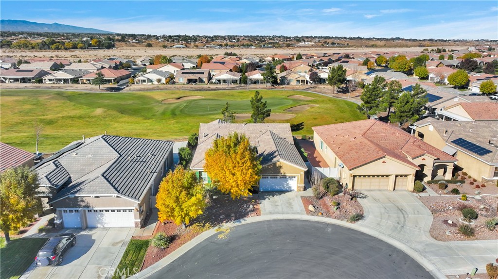 an aerial view of residential houses with outdoor space and ocean view